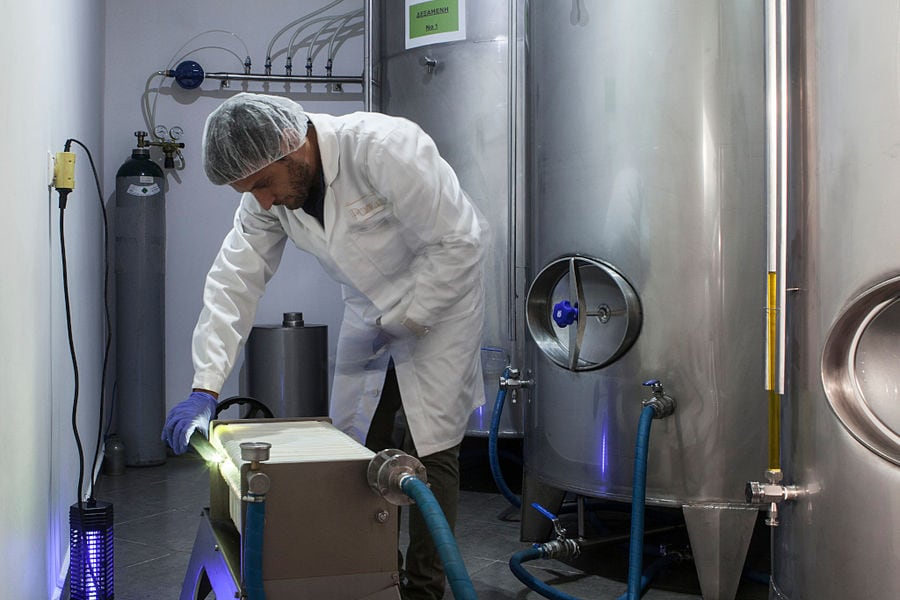 man working at 'Pamako' olive oil plant using the equipment